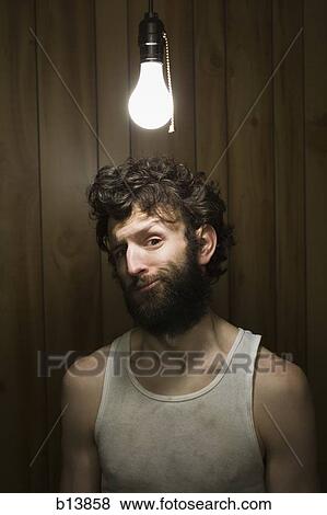 Man standing under light bulb View Large Photo Image Stock Photo - Man standing under light bulb. Fotosearch