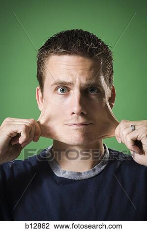 Stock Image - Man stretching skin on face. Fotosearch