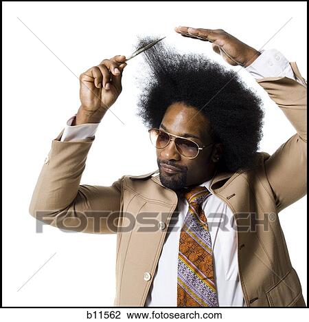 Man with an afro in beige suit combing with a hair pick View Large Photo Image Stock Image - Man with an afro in beige suit combing with a hair pick. Fotosearch
