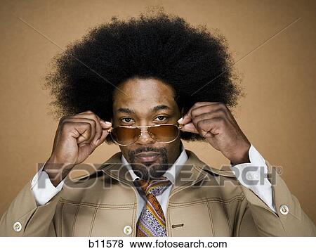 Man with an afro in beige suit putting on sunglasses View Large Photo Image Stock Photo - Man with an afro in beige suit putting on sunglasses. Fotosearch