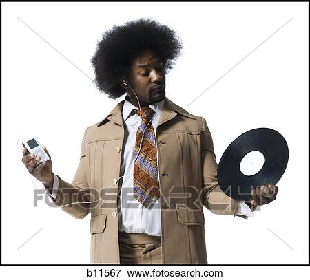 Man with an afro in beige suit listening to MP3 player View Large Photo Image Stock Photo - Man with an afro in beige suit listening to MP3 player. Fotosearch
