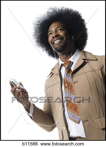 Man with an afro in beige suit listening to MP3 player View Large Photo Image Stock Photograph - Man with an afro in beige suit listening to MP3 player. Fotosearch