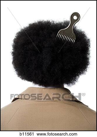 Stock Image - Man with an afro in beige suit with hair pick in hair. Fotosearch