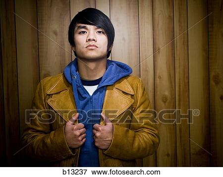 Man with hoodie and leather jacket posing View Large Photo Image Stock Photo - Man with hoodie and leather jacket posing. Fotosearch