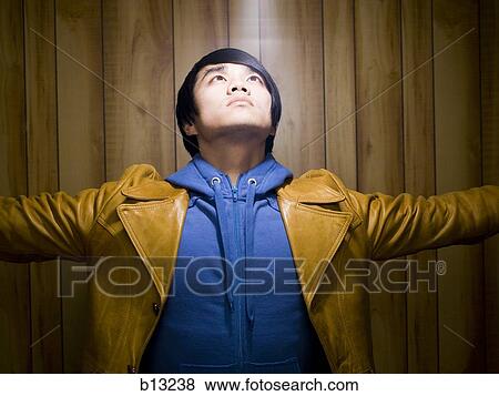 Man with hoodie and leather jacket looking up View Large Photo Image Stock Photo - Man with hoodie and leather jacket looking up. Fotosearch