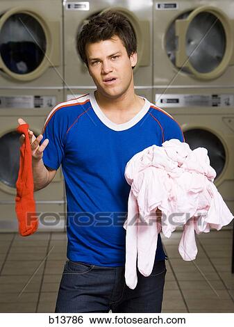 Man with red sock and pink clothing at Laundromat View Large Photo Image Stock Photograph - Man with red sock and pink clothing at Laundromat. Fotosearch