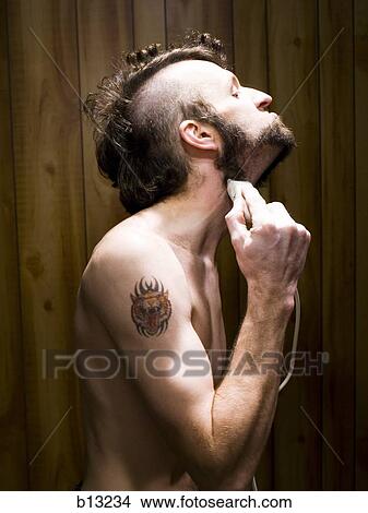 Picture - Man with tattoo shaving beard. Fotosearch