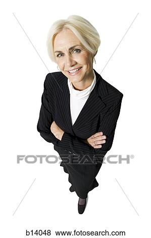 Stock Photo - Mature businesswoman smiling with arms crossed from above. Fotosearch
