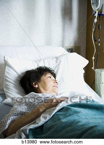 Stock Image - Mature woman in hospital bed. Fotosearch
