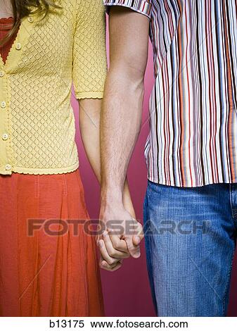 Mid section of couple holding hands View Large Photo Image Stock Photography - Mid section of couple holding hands. Fotosearch