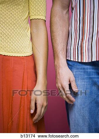 Mid section of couple standing View Large Photo Image Picture - Mid section of couple standing. Fotosearch