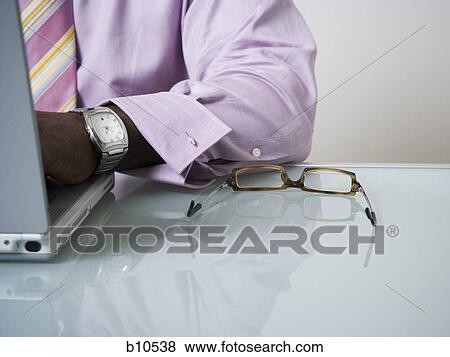 Mid section view of a businessman using a laptop View Large Photo Image Stock Photo - Mid section view of a businessman using a laptop. Fotosearch