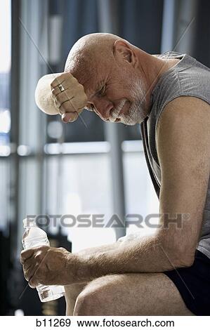 Middle aged man taking a break from working out View Large Photo Image Stock Photo - Middle aged man taking a break from working out. Fotosearch