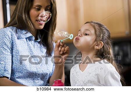 Picture - Mother and young daughter blowing bubbles. Fotosearch