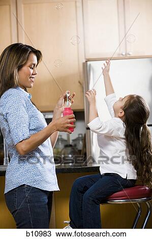 Mother and young daughter blowing bubbles View Large Photo Image Stock Image - Mother and young daughter blowing bubbles. Fotosearch