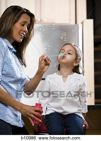 Mother and young daughter blowing bubbles View Large Photo Image Stock Photograph - Mother and young daughter blowing bubbles. Fotosearch