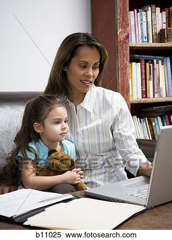 Stock Photography - Mother and young daughter working on laptop computer. Fotosearch