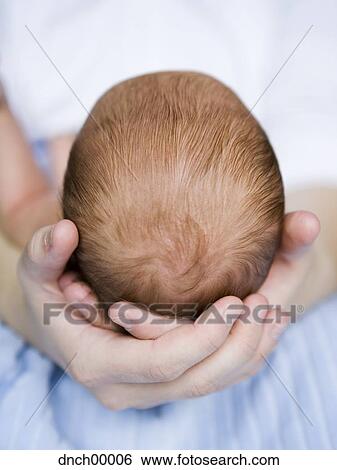Stock Photograph - Mother holding newborn's head. Fotosearch