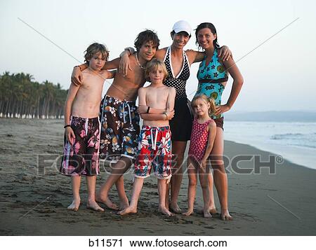 Stock Image - Mother with sons and daughters on beach. Fotosearch