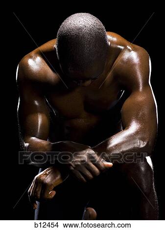 Picture - Muscular athlete in dark room. Fotosearch