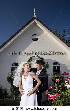 Newlywed couple standing in front of a chapel and smiling View Large Photo Image Stock Image - Newlywed couple standing in front of a chapel and smiling. Fotosearch