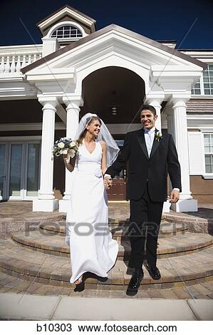 Newlywed couple walking down the steps in front of a building View Large Photo Image Stock Image - Newlywed couple walking down the steps in front of a building. Fotosearch