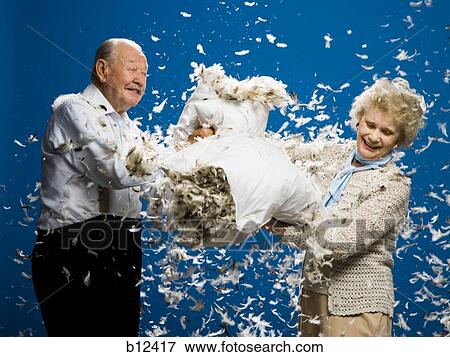 Stock Photo - Older couple pillow fighting. Fotosearch