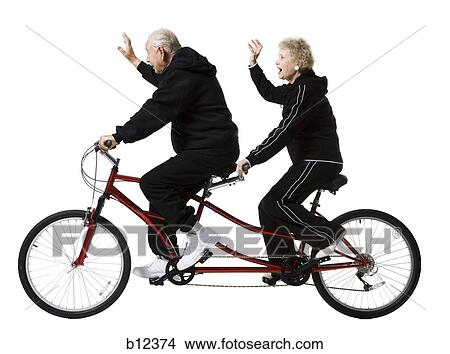 Picture - Older couple riding a tandem bicycle. Fotosearch