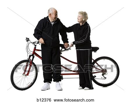 Stock Photograph - Older couple riding a tandem bicycle. Fotosearch