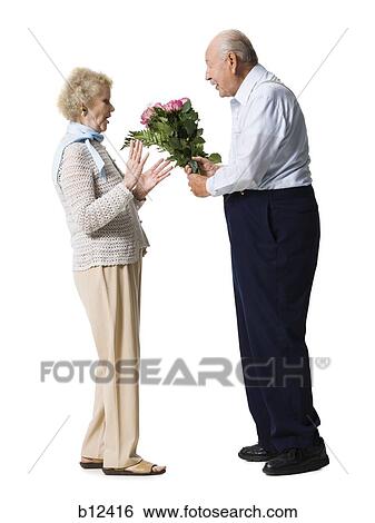 Older man giving wife bouquet of pink roses View Large Photo Image Stock Photograph - Older man giving wife bouquet of pink roses. Fotosearch
