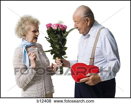 Stock Photo - Older man giving wife Valentines chocolate. Fotosearch
