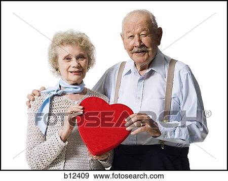 Stock Photo - Older man giving wife Valentines chocolate. Fotosearch
