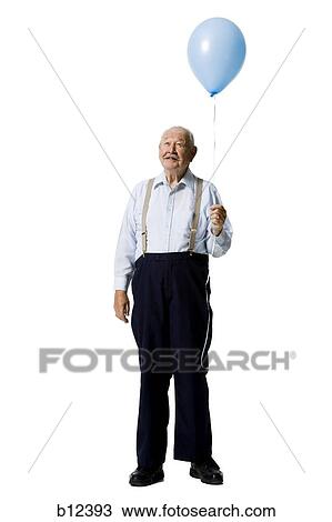 Stock Image - Older man holding balloon. Fotosearch