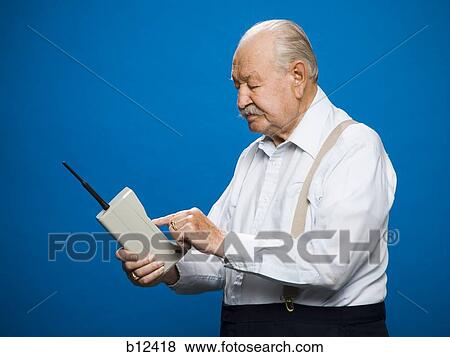 Older man making call on retro wireless phone View Large Photo Image Stock Photo - Older man making call on retro wireless phone. Fotosearch