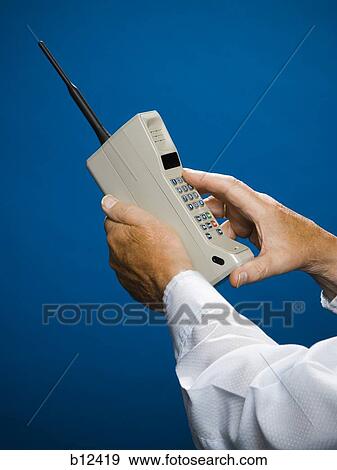 Older man making call on retro wireless phone View Large Photo Image Stock Photo - Older man making call on retro wireless phone. Fotosearch