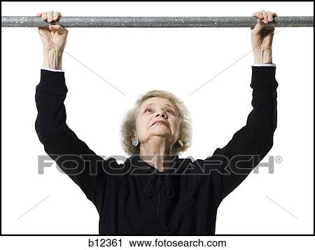 Stock Image - Older woman doing pull up exercises. Fotosearch