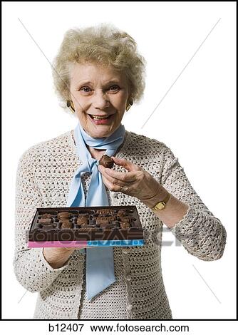 Stock Photo - Older woman holding a box of chocolates. Fotosearch