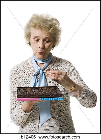 Stock Photograph - Older woman holding a box of chocolates. Fotosearch