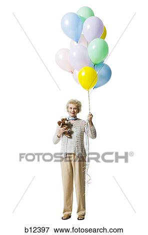 Older woman holding balloons View Large Photo Image Stock Photo - Older woman holding balloons. Fotosearch