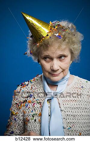 Stock Photo - Older woman wearing a party hat. Fotosearch