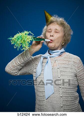 Older woman with noisemaker and party hat View Large Photo Image Picture - Older woman with noisemaker and party hat. Fotosearch