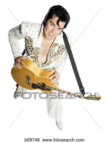 Overhead portrait of an Elvis impersonator holding a guitar View Large Photo Image Stock Photo - Overhead portrait of an Elvis impersonator holding a guitar. Fotosearch