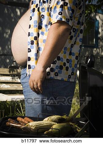Stock Photo - Overweight man by barbecue grill. Fotosearch