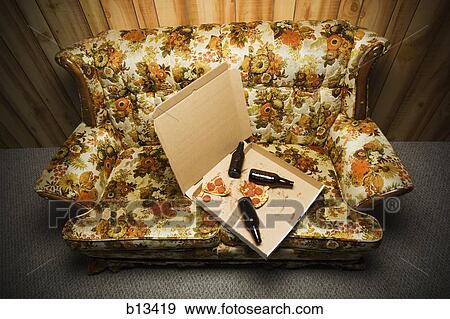 Stock Photo - Pizza box and beer bottles on sofa. Fotosearch