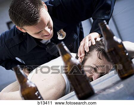 Police officer arresting man lying down with beer bottles View Large Photo Image Stock Image - Police officer arresting man lying down with beer bottles. Fotosearch