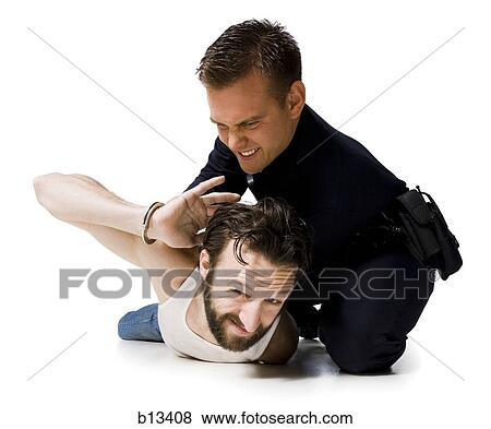 Stock Photo - Police officer arresting man lying down with handcuffs. Fotosearch