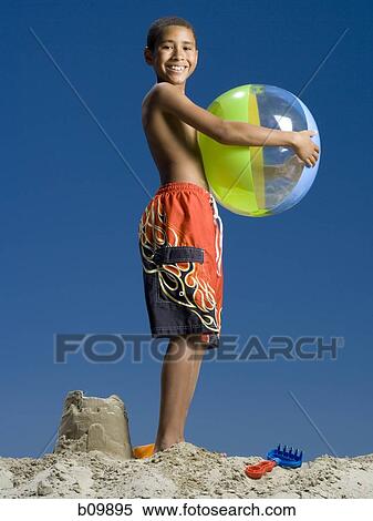 Portrait of a boy holding a beach ball View Large Photo Image Stock Photography - Portrait of a boy holding a beach ball. Fotosearch
