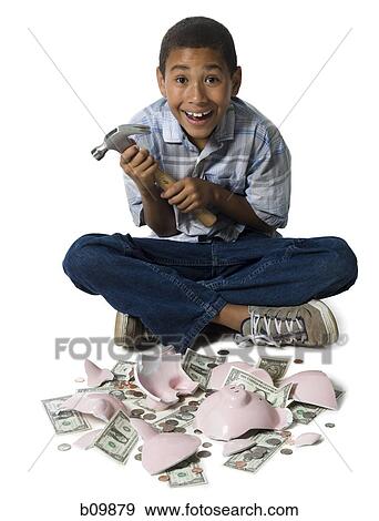 Stock Photo - Portrait of a boy holding a hammer with a broken piggy bank in front of him. Fotosearch