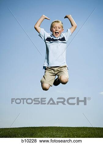 Portrait of a boy jumping with his arms raised View Large Photo Image Stock Photo - Portrait of a boy jumping with his arms raised. Fotosearch