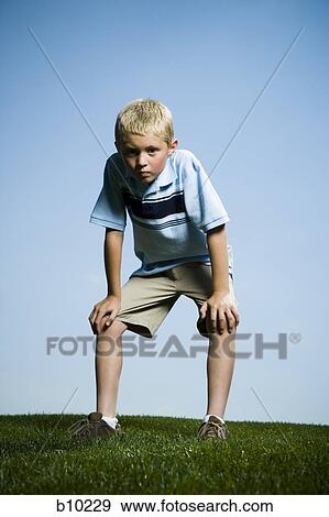 Portrait of a boy standing with his hand on his knees View Large Photo Image Stock Photo - Portrait of a boy standing with his hand on his knees. Fotosearch